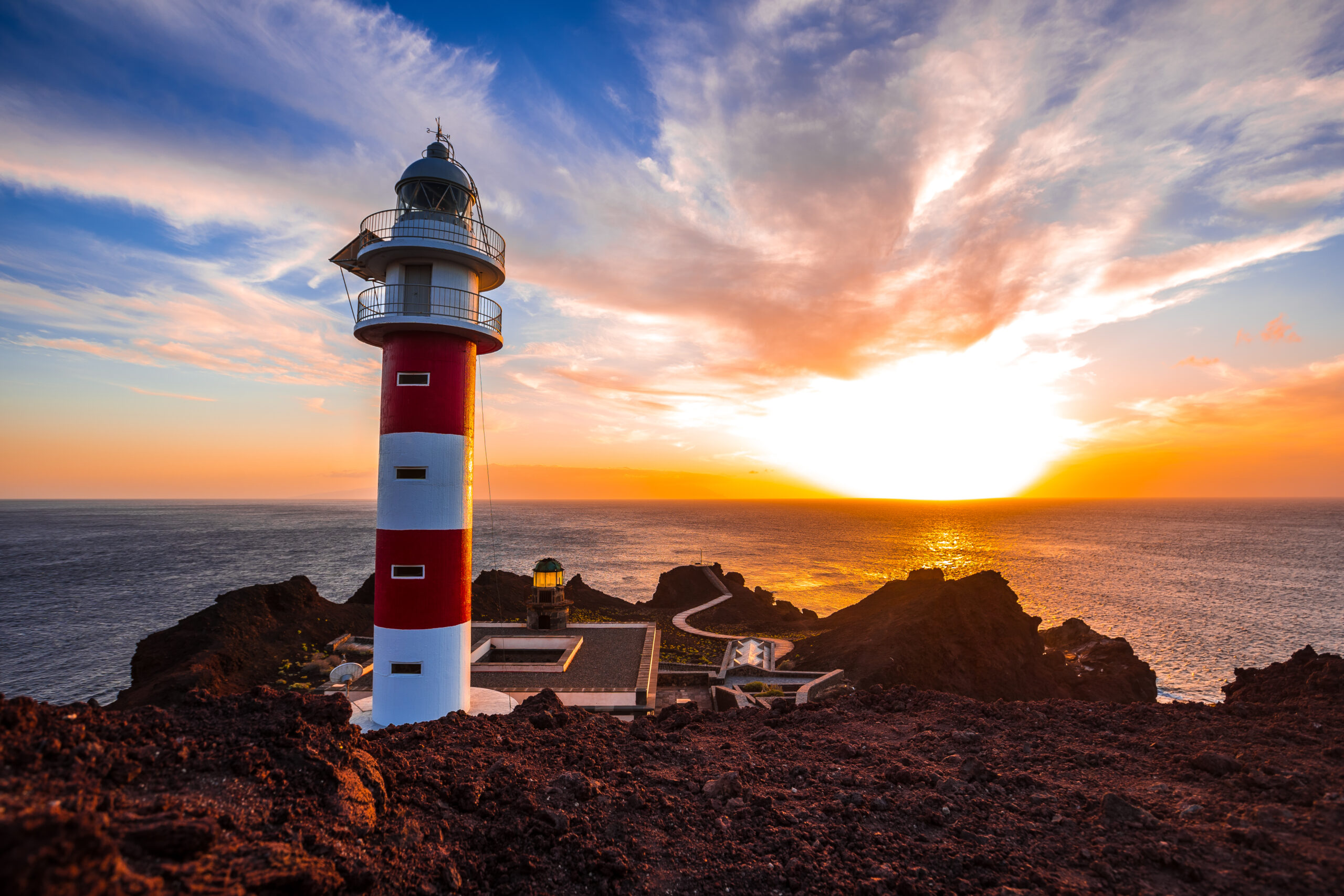 zonsondergang bij Punta de Teno op tenerife bij vuurtoren met rood witte strepen