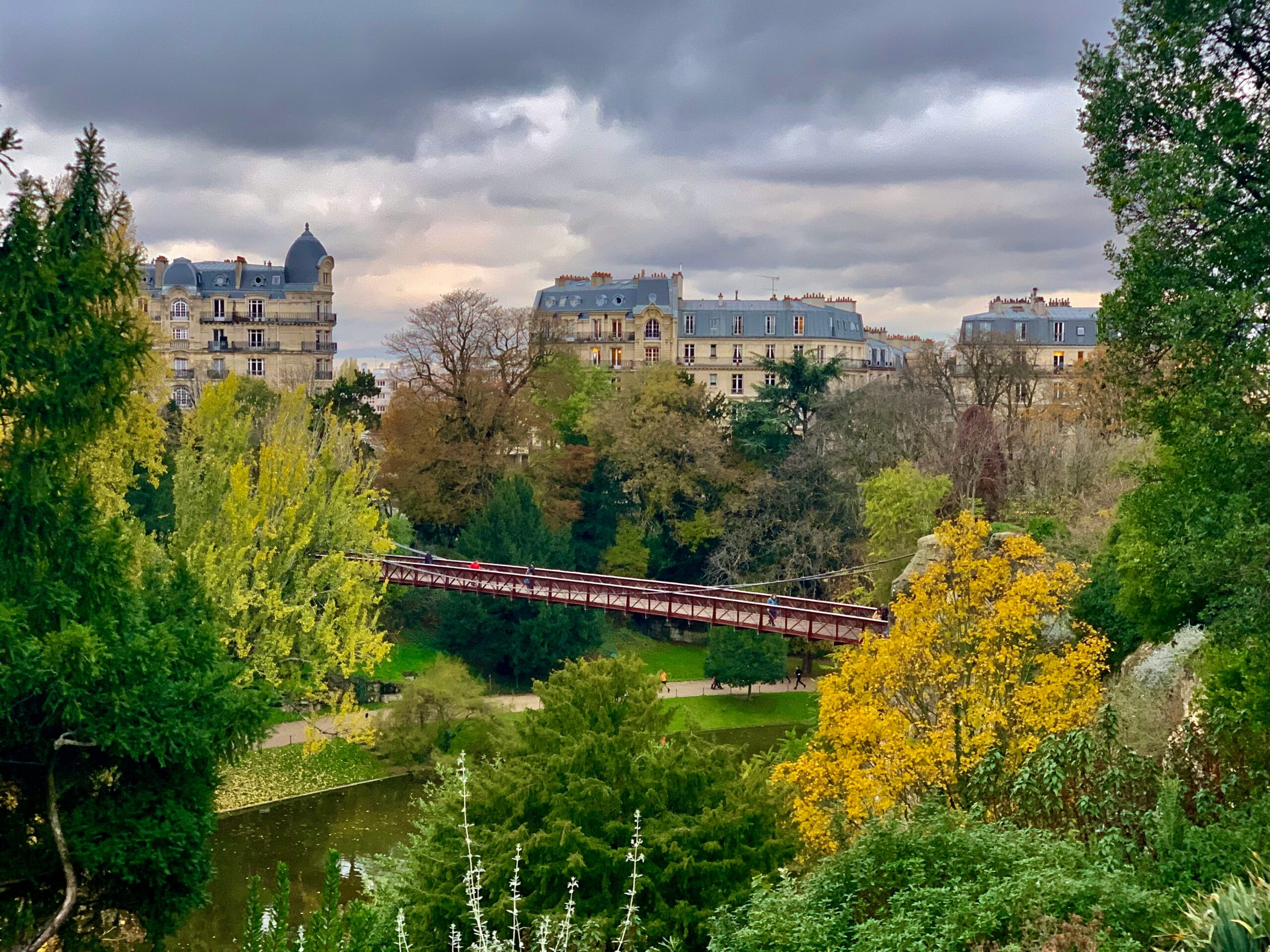 hangbrug in het Parc des Buttes-Chaumont in Parijs dit park zit vol met groten en hangbruggen ideaal voor een unieke daguitstap in Parijs